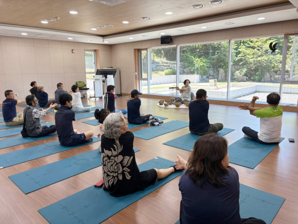 산불 피해 주민이 싱잉볼 명상 전 몸을 이완하고 있다.