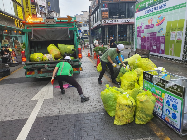 환경관리요원들이 대전 0시 축제 현장 쓰레기를 치우고 있다.<br>