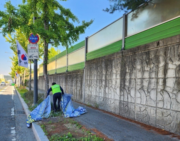 유성구청 직원이 인도의 불법현수막을 제거하고 있다.