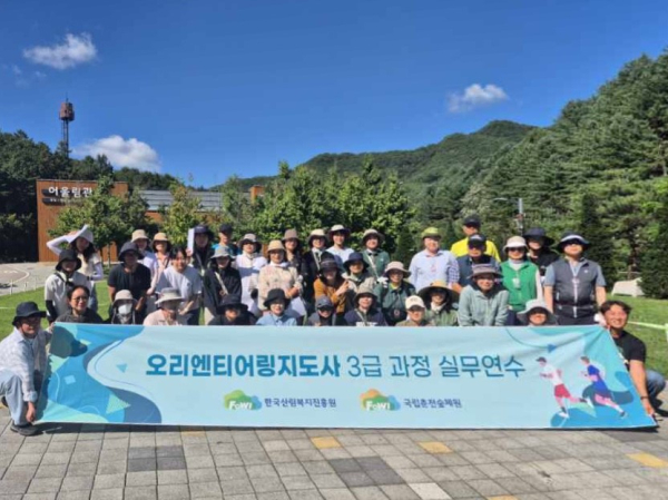 지난 4일 실무연수 과정을 마친 참가자들이 숲속에서 단체 기념 촬영을 하고 있다.