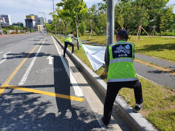 유성구청 직원이 대로변의 불법현수막을 정비하고 있다
