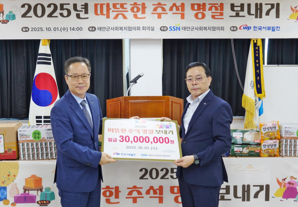 이경현 서부발전 조달협력처장(왼쪽)이 이기용 태안군사회복지협의회장에게 지원금을 전달하는 모습