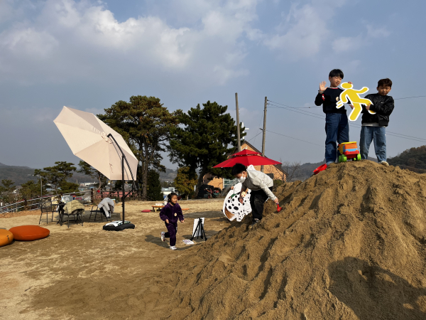 장평면에 조성된 야외 모래 구릉지에서 아이들이 놀이 프로그램을 즐기며 활기찬 시간을 보내고 있다.