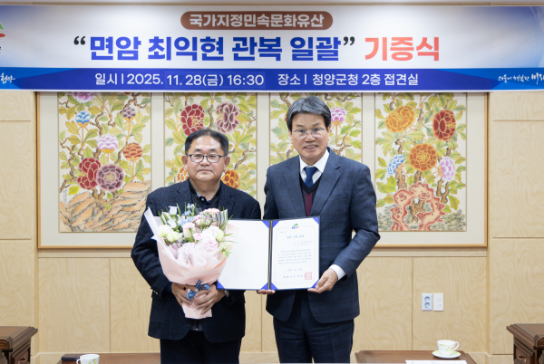김돈곤 군수(오른쪽)와 기증자인 최진홍 박사(왼쪽)가 지난 11월 28일 국가민속문화유산 ‘면암 최익현 관복 일괄’ 기증식을 가진 뒤 기념촬영