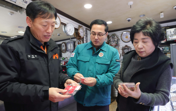 박희조 동구청장이 인동시장 상점가 전기 콘센트에 자동소화패치를 설치하는 모습