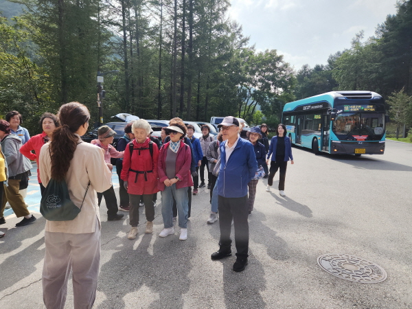 춘천시 지역 어르신들이 시내버스를 타고 국립춘천숲체원에 도착해 프로그램 과정장의 안내를 받고 있다.