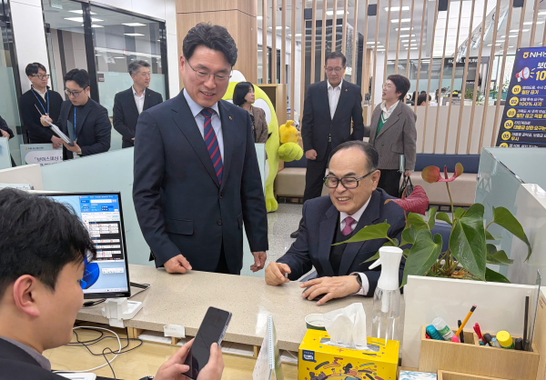 강춘식 회장(오른쪽)이 오주현본부장(왼쪽)의 안내를 받으며         농협은행 창구에서 보이스피싱 보상보험을 가입하고 있다.