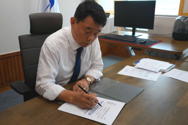 첫 결재로 서천트고하시장 재건축에 서명하고 있는 유승광 군수